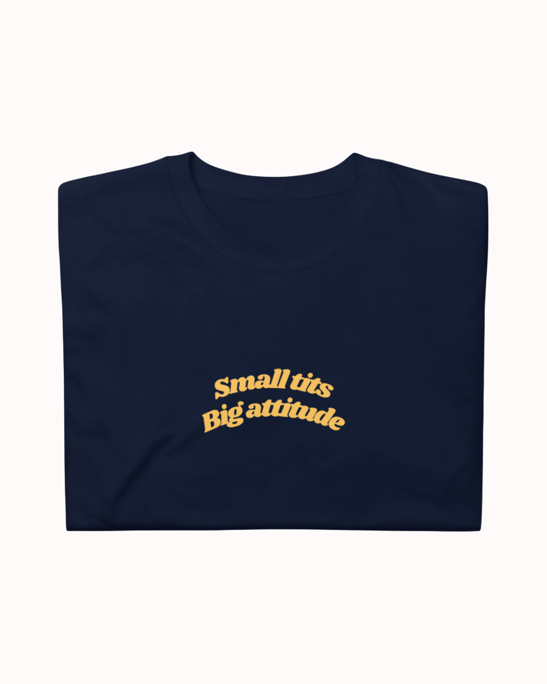 Folded Navy t-shirt featuring the ironic phrase "Small tits. Big attitude". Perfect for fans of funny merchandise, bold humor, and witty sarcasm.