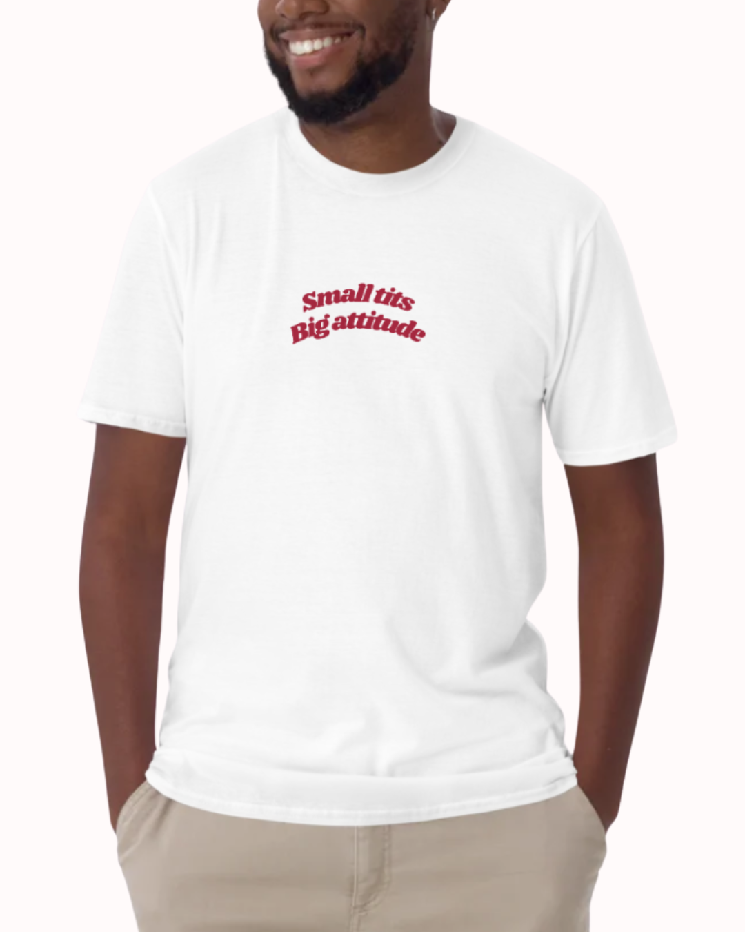 Front view of a White t-shirt worn by a smiling man, featuring the phrase "Small tits. Big attitude" on the chest and back. Perfect for fans of funny merchandise, bold humor, and witty sarcasm.