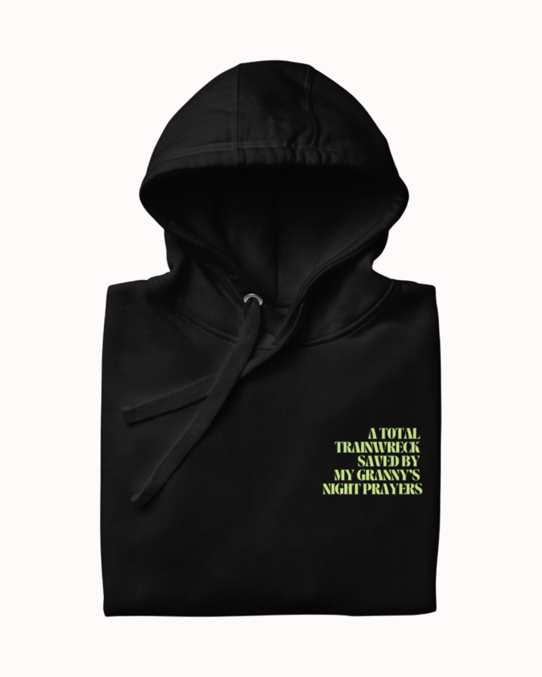 Folded Black hoodie featuring the ironic phrase "A total trainwreck saved my granny's night prayers". Perfect for fans of funny merchandise, bold humor, and witty sarcasm.