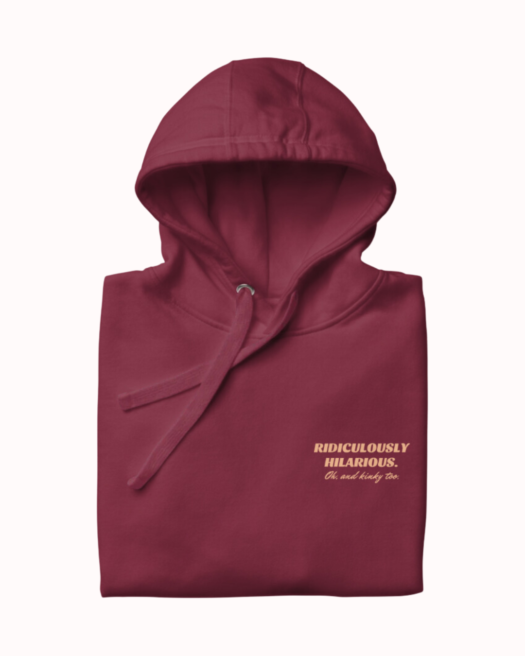 Folded maroon hoodie featuring the ironic phrase 'Ridiculously hilarious. Oh, and kinky too'. Perfect for fans of funny merchandise, bold humor, and witty sarcasm.