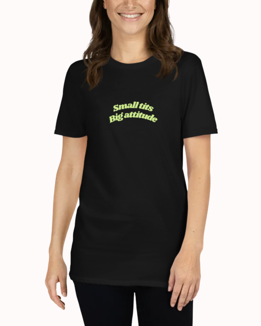 Front view of a Black t-shirt worn by a smiling woman, featuring the phrase "Small tits. Big attitude" on the chest and back. Perfect for fans of funny merchandise, bold humor, and witty sarcasm.