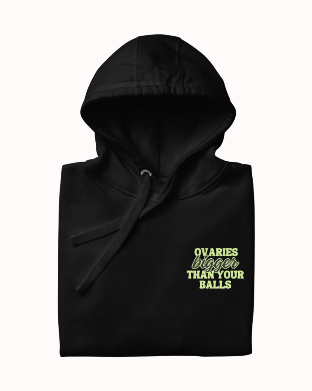Folded black hoodie featuring the ironic phrase 'Ovaries bigger than your balls'. Perfect for fans of funny merchandise, bold humor, and witty sarcasm.