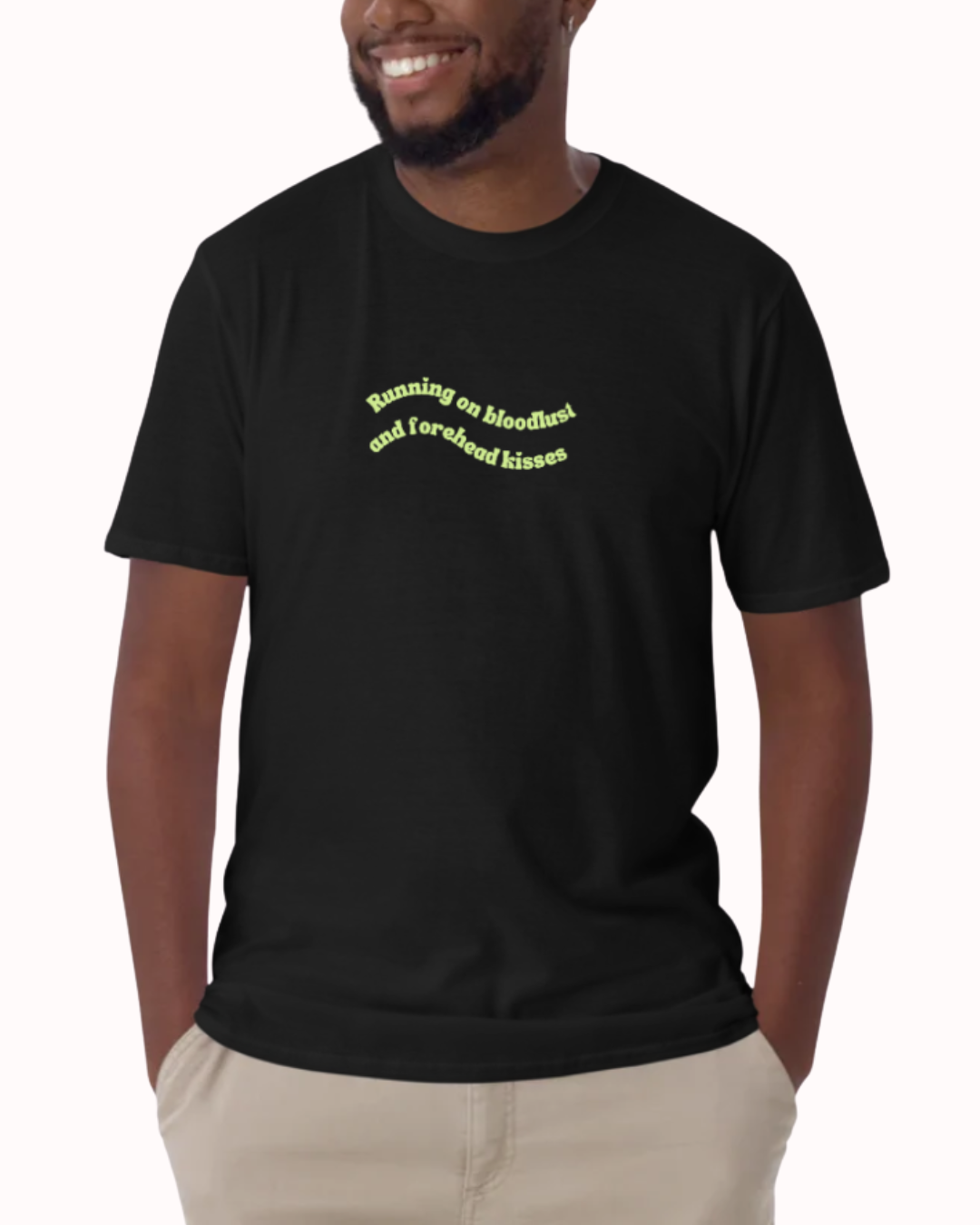 Front view of a Black t-shirt worn by a smiling man, featuring the phrase "Running on bloodlust and forehead kisses" on the chest and back. Perfect for fans of funny merchandise, bold humor, and witty sarcasm.