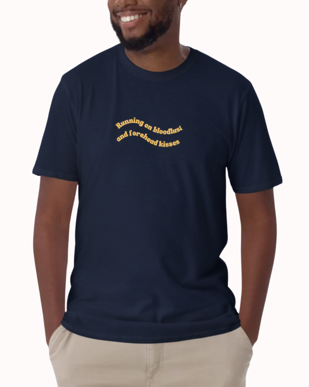 Front view of a Navy t-shirt worn by a smiling man, featuring the phrase "Running on bloodlust and forehead kisses" on the chest and back. Perfect for fans of funny merchandise, bold humor, and witty sarcasm.