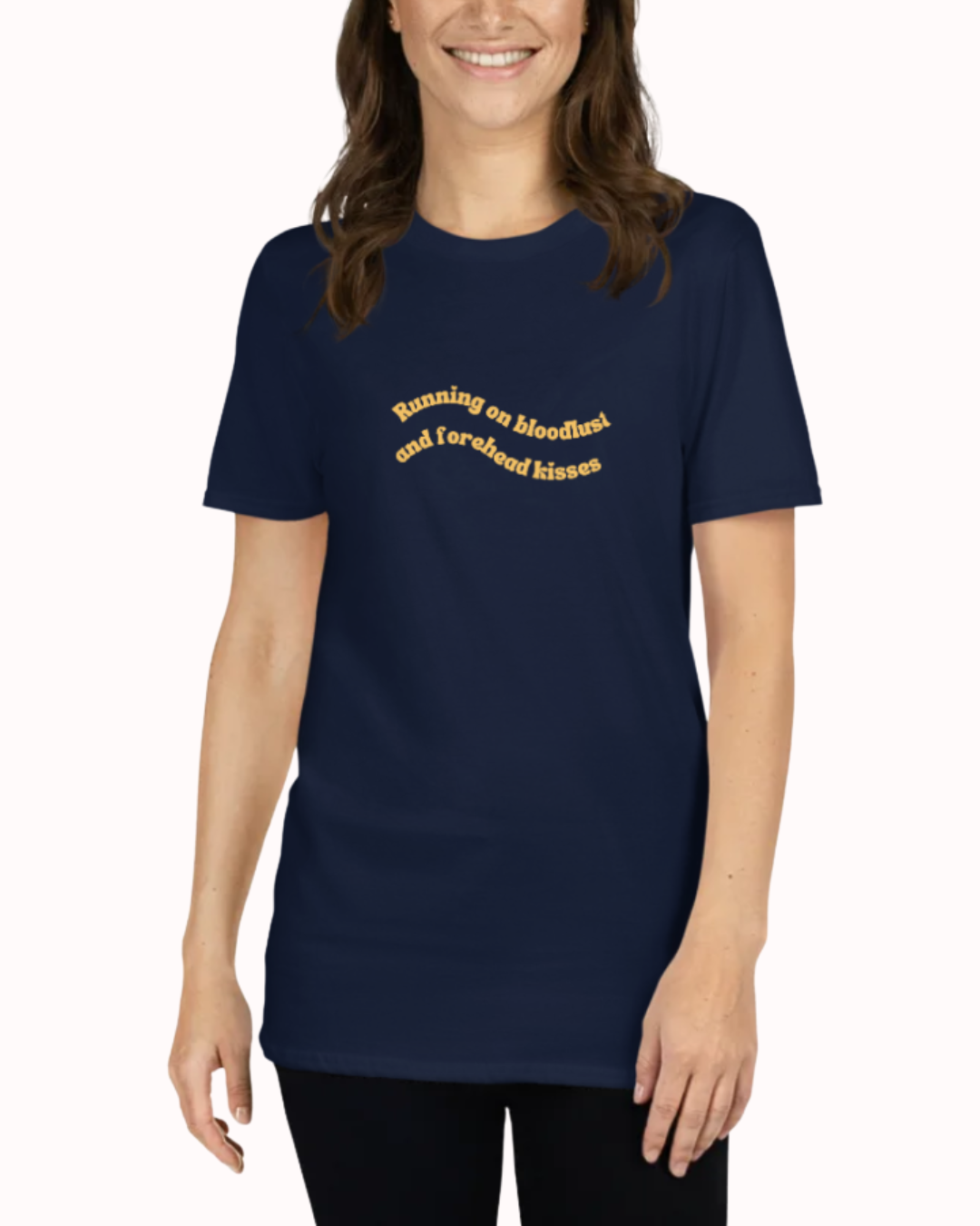 Front view of a Navy t-shirt worn by a smiling woman, featuring the phrase "Running on bloodlust and forehead kisses" on the chest and back. Perfect for fans of funny merchandise, bold humor, and witty sarcasm.