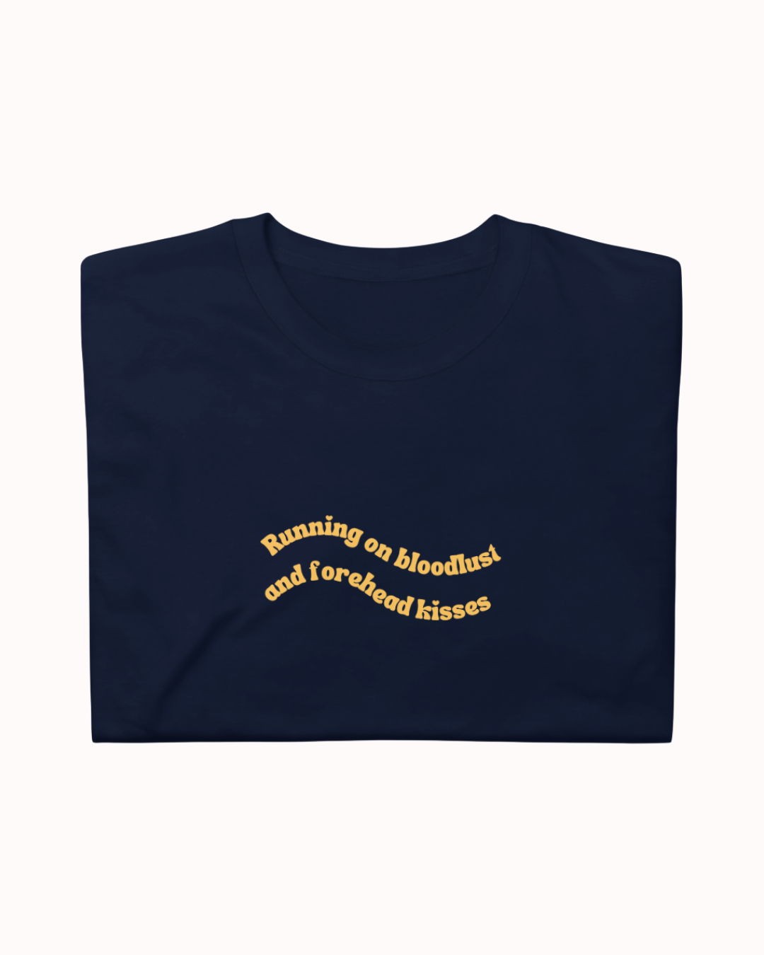 Folded Navy t-shirt featuring the ironic phrase "Running on bloodlust and forehead kisses". Perfect for fans of funny merchandise, bold humor, and witty sarcasm.