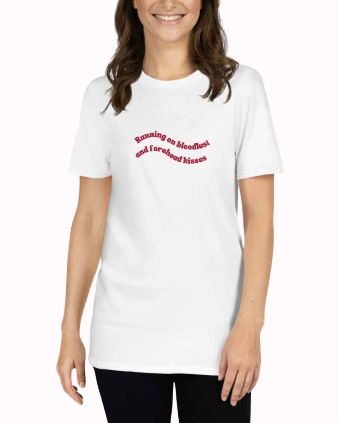 Front view of a White t-shirt worn by a smiling woman, featuring the phrase "Running on bloodlust and forehead kisses" on the chest and back. Perfect for fans of funny merchandise, bold humor, and witty sarcasm.