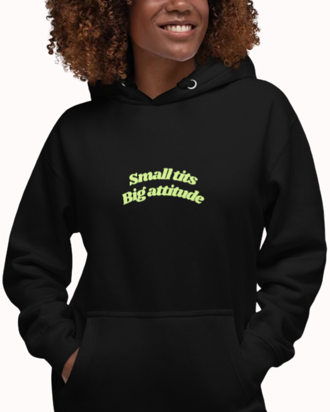 Front view of a Black hoodie worn by a smiling woman, featuring the phrase "Small tits. Big attitude" on the chest and back. Perfect for fans of funny merchandise, bold humor, and witty sarcasm.