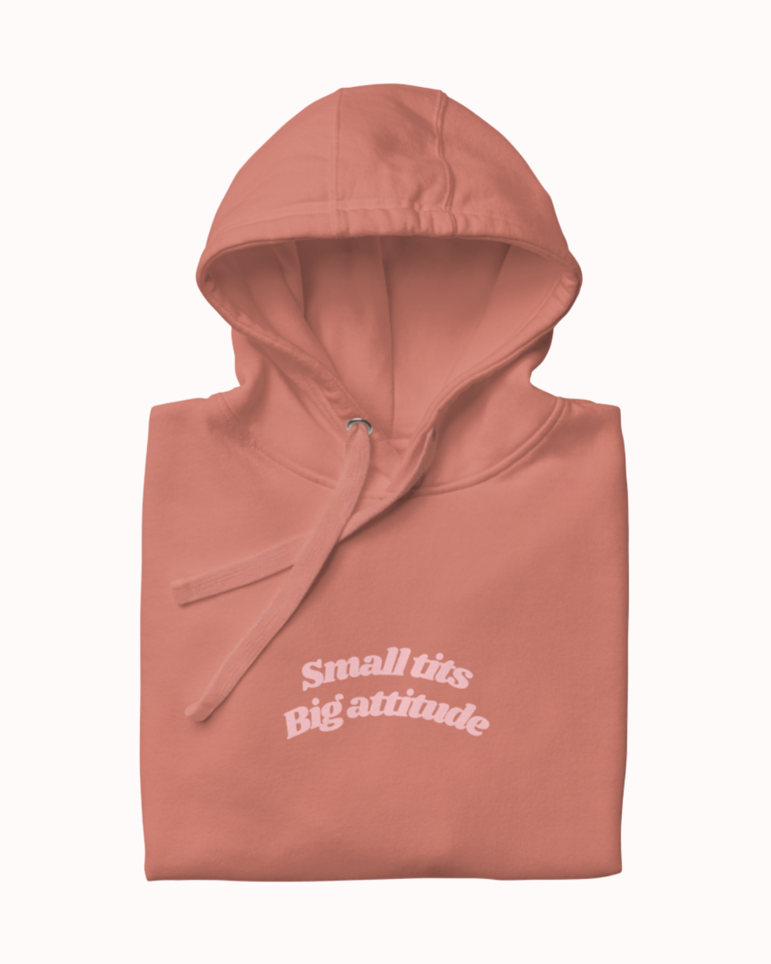 Folded Dusty Rose hoodie featuring the ironic phrase "Small tits. Big attitude". Perfect for fans of funny merchandise, bold humor, and witty sarcasm.