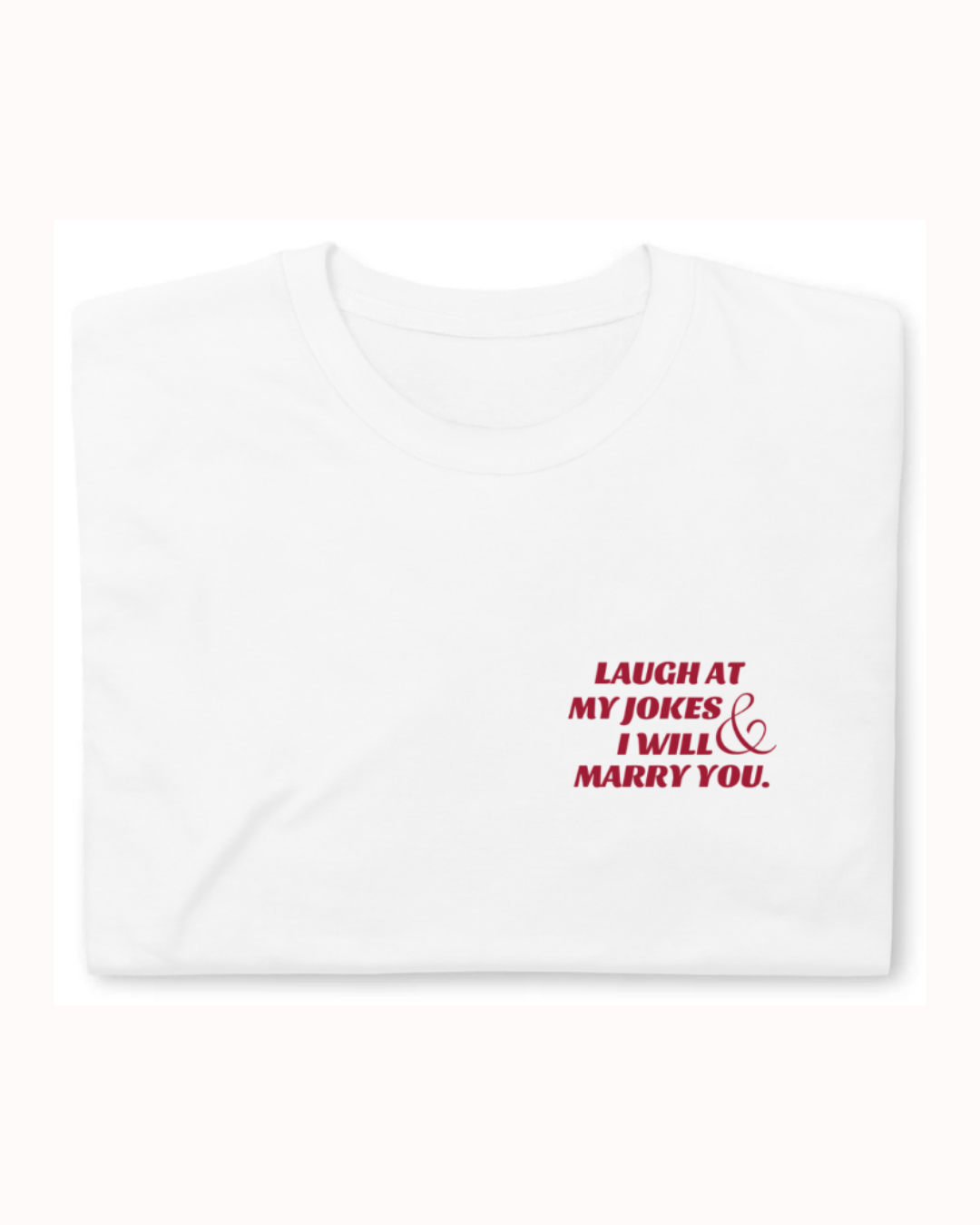 Folded white T-Shirt featuring the ironic phrase 'Laugh at my jokes and I will marry you'. Perfect for fans of funny merchandise, bold humor, and witty sarcasm.