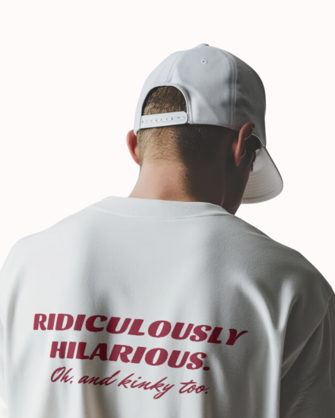 Back view of a white T-Shirt featuring the phrase 'Ridiculously hilarious. Oh, and kinky too' on the back. Perfect for fans of funny merchandise, bold humor, and witty sarcasm.