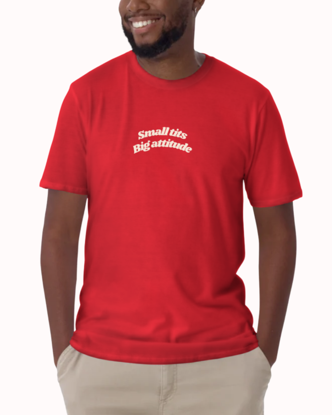 Front view of a Red t-shirt worn by a smiling man, featuring the phrase "Small tits. Big attitude" on the chest and back. Perfect for fans of funny merchandise, bold humor, and witty sarcasm.