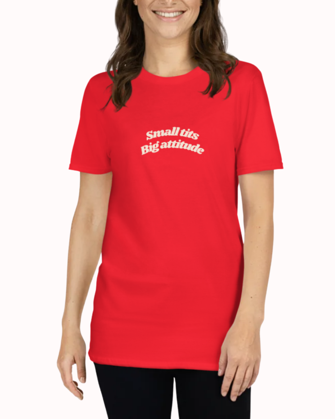 Front view of a Red t-shirt worn by a smiling woman, featuring the phrase "Small tits. Big attitude" on the chest and back. Perfect for fans of funny merchandise, bold humor, and witty sarcasm.