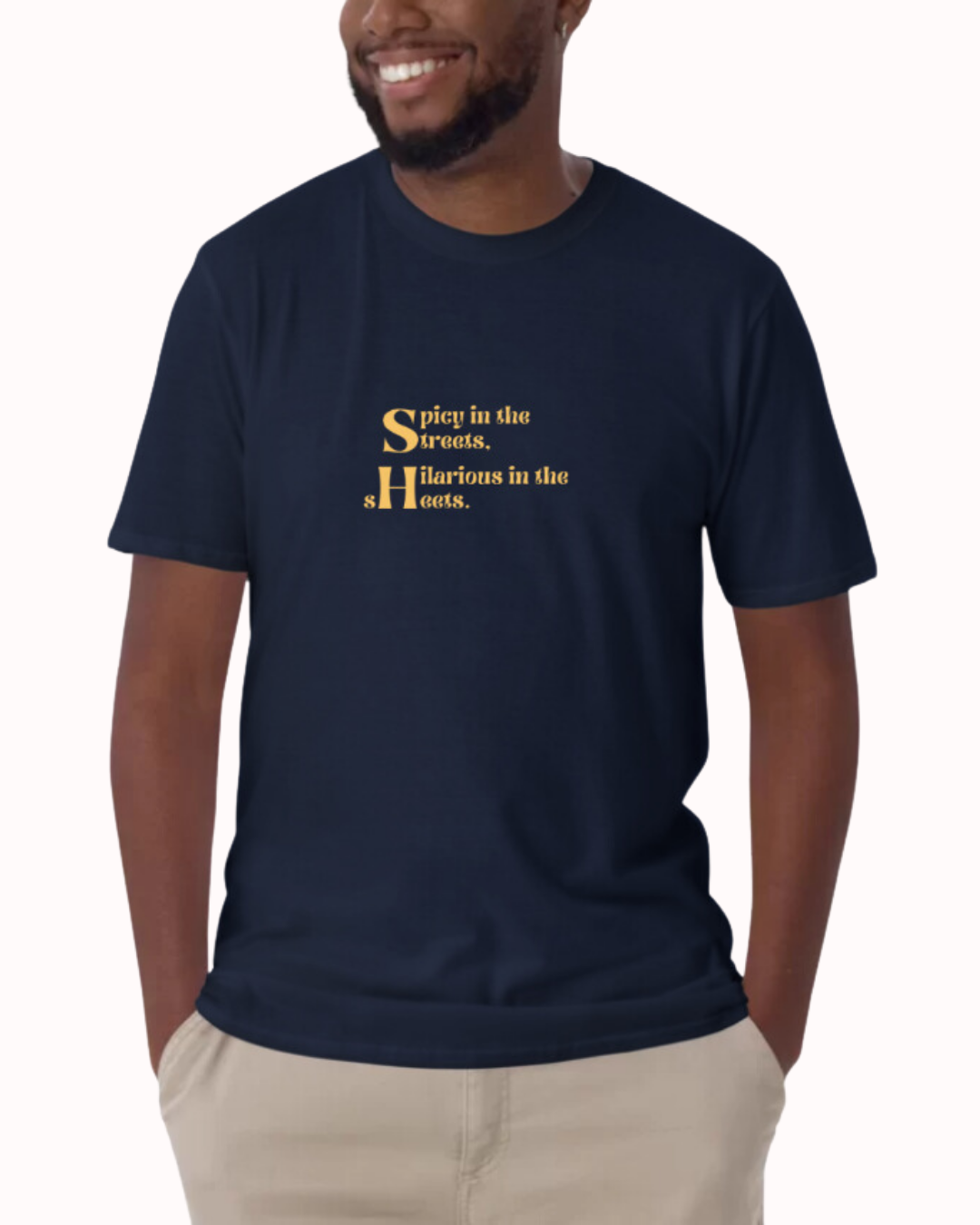 Front view of a navy T-Shirt worn by a smiling man, featuring the phrase 'Spicy in the streets, Hilarious in the sheets' on the chest. Perfect for fans of funny merchandise, bold humor, and witty sarcasm.