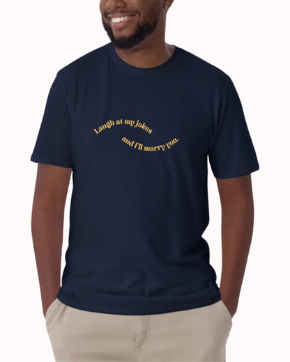 Front view of a navy T-Shirt worn by a smiling man, featuring the phrase 'Laugh at my jokes and I will marry you' on the chest. Perfect for fans of funny merchandise, bold humor, and witty sarcasm. 