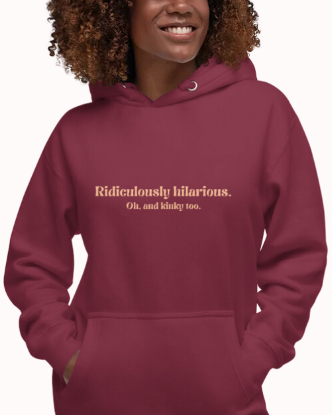 Front view of a maroon hoodie worn by a smiling woman, featuring the phrase 'Ridiculously hilarious. Oh, and kinky too' on the chest. Perfect for fans of funny merchandise, bold humor, and witty sarcasm.