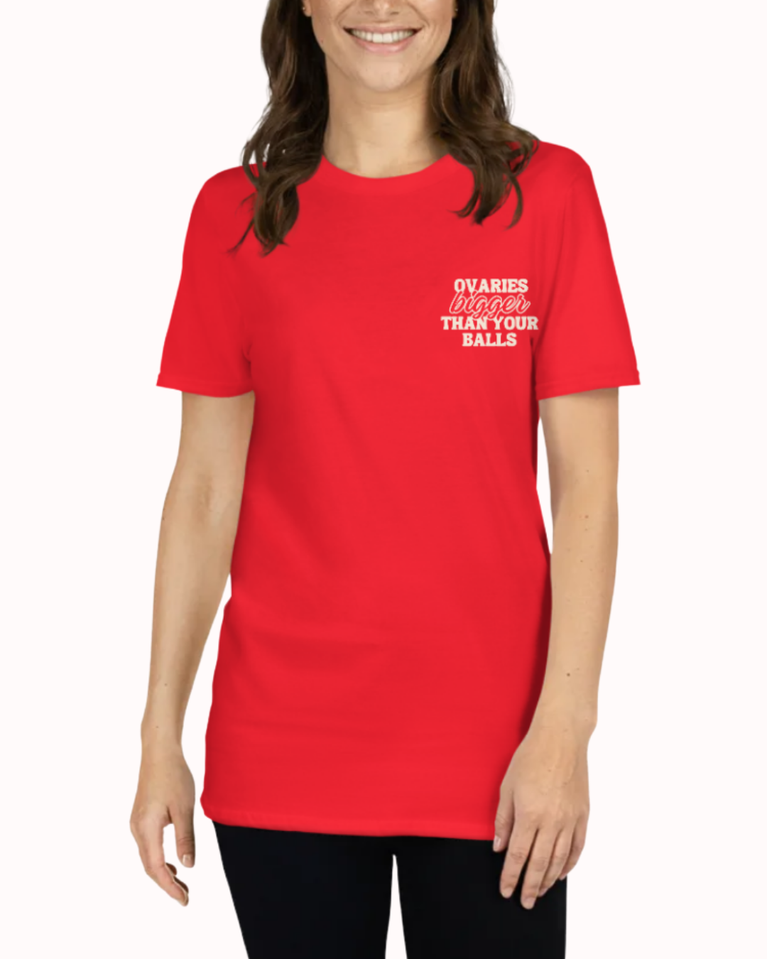 Front view of a Red t-shirt worn by a smiling woman, featuring the phrase "Ovaries bigger than your balls" on the chest and back. Perfect for fans of funny merchandise, bold humor, and witty sarcasm.