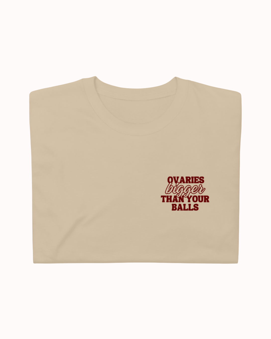 Folded Sand t-shirt featuring the ironic phrase "Ovaries bigger than your balls". Perfect for fans of funny merchandise, bold humor, and witty sarcasm.