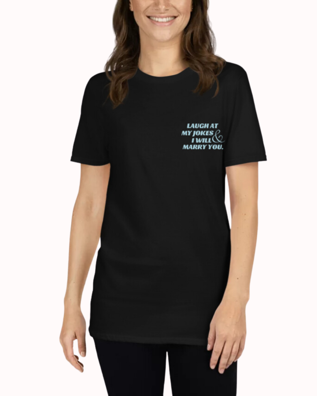 Front view of a black T-Shirt worn by a smiling woman, featuring the phrase 'Laugh at my jokes and I will marry you' on the chest and back. Perfect for fans of funny merchandise, bold humor, and witty sarcasm.