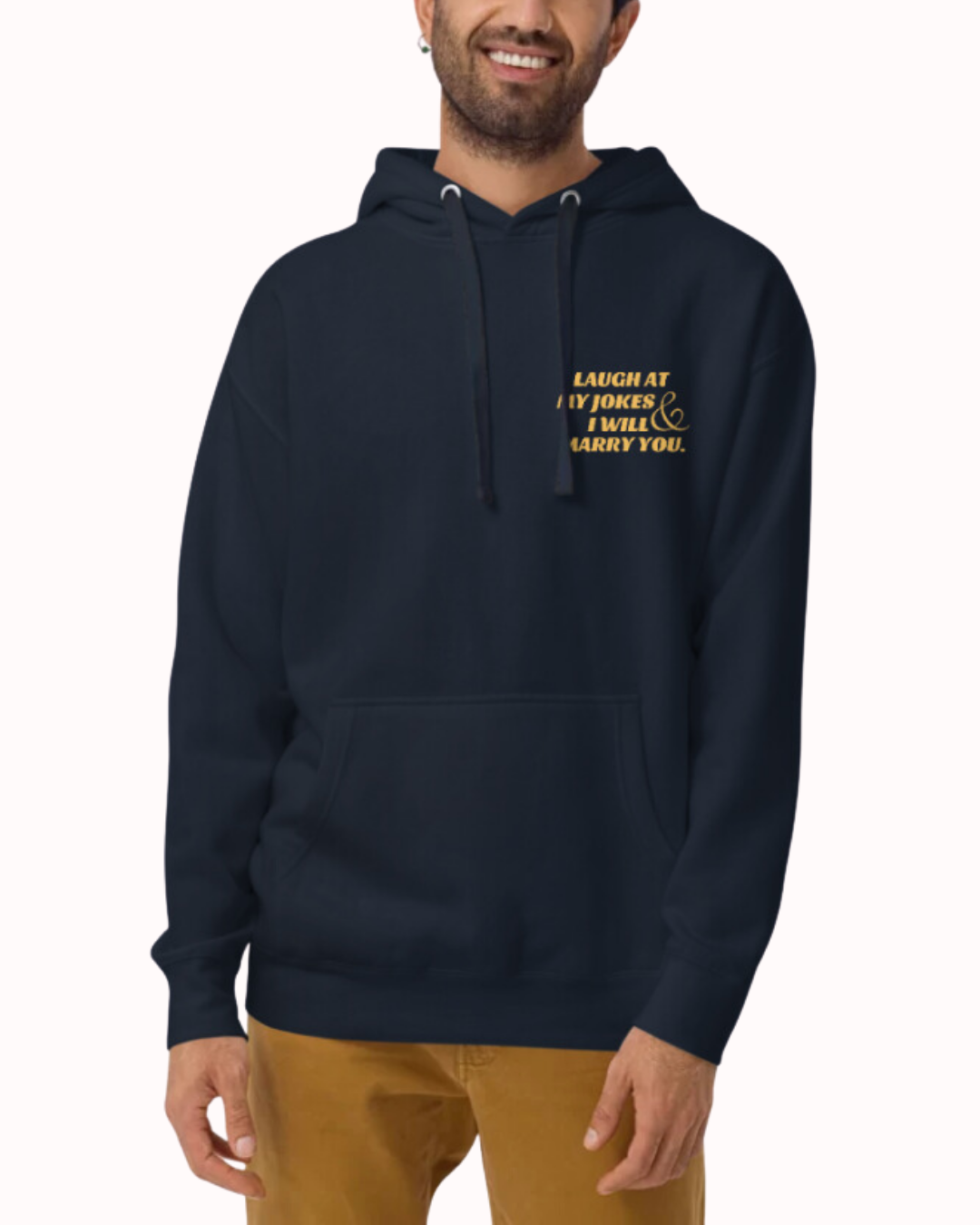 Front view of a navy blazer hoodie worn by a smiling man, featuring the phrase 'Laugh at my jokes and I will marry you' on the chest and back. Perfect for fans of funny merchandise, bold humor, and witty sarcasm.