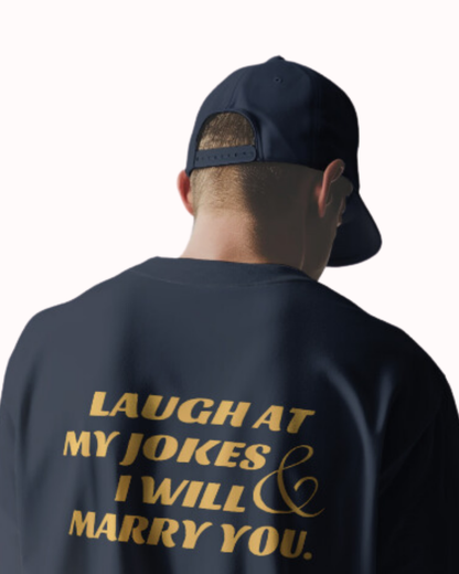 Back view of a navy T-Shirt featuring the phrase 'Laugh at my jokes and I will marry you' on the back. Perfect for fans of funny merchandise, bold humor, and witty sarcasm.