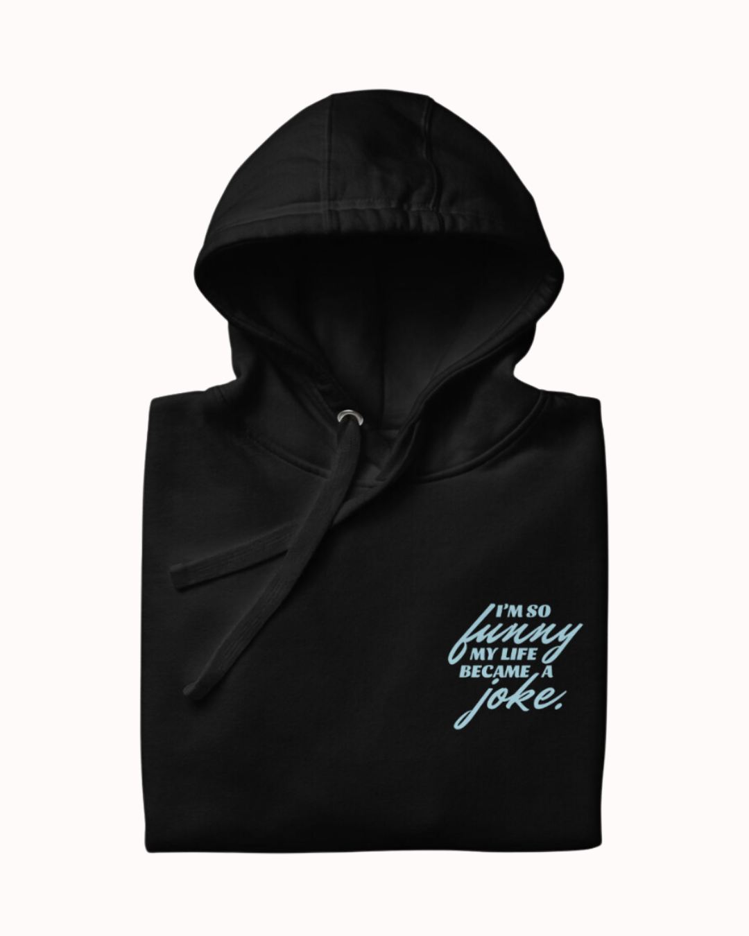 Folded black hoodie featuring the ironic phrase 'I'm so funny my life became a joke'. Perfect for fans of funny merchandise, bold humor, and witty sarcasm.