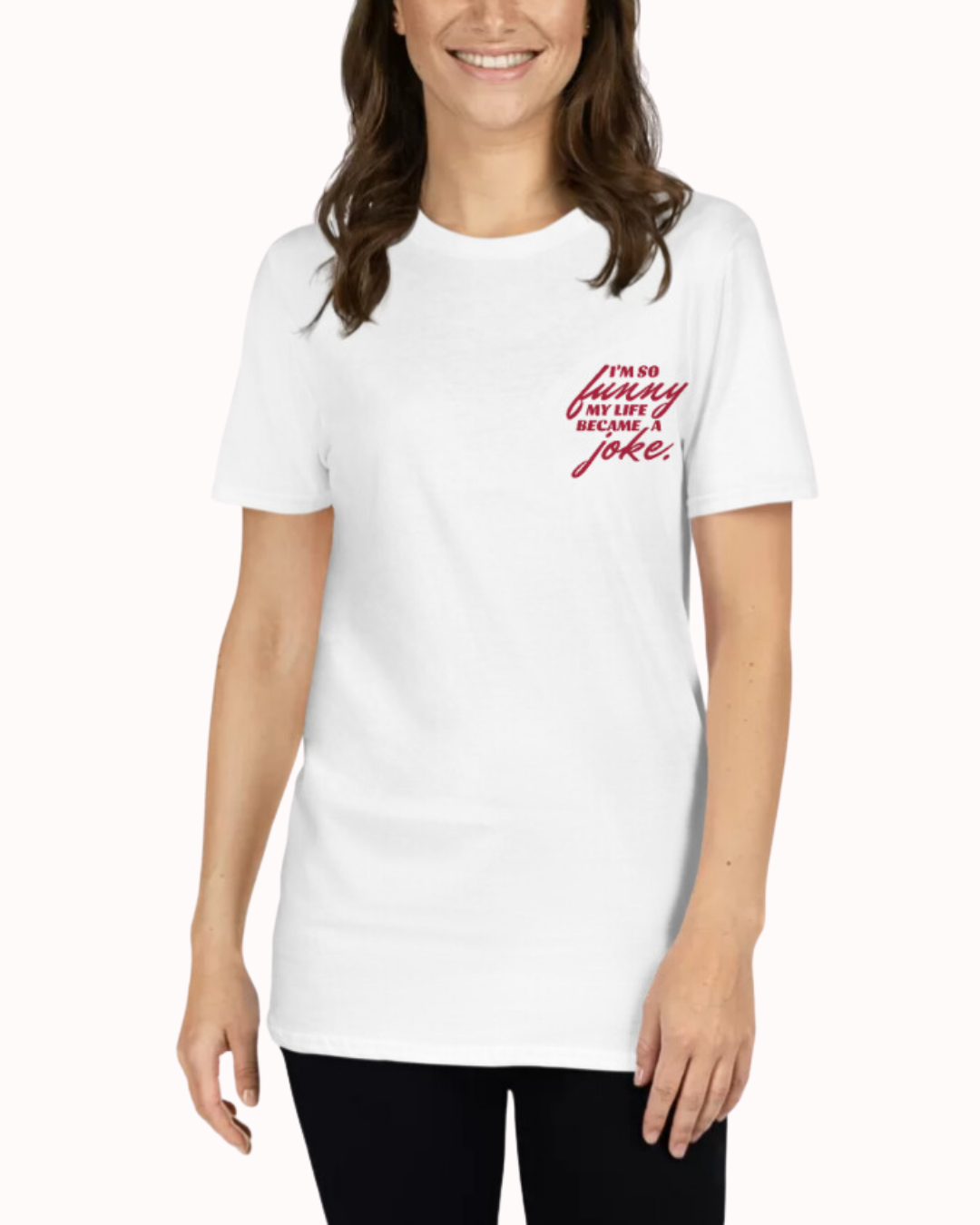 Front view of a white T-Shirt worn by a smiling woman, featuring the phrase 'I'm so funny my life became a joke' on the chest and back. Perfect for fans of funny merchandise, bold humor, and witty sarcasm.