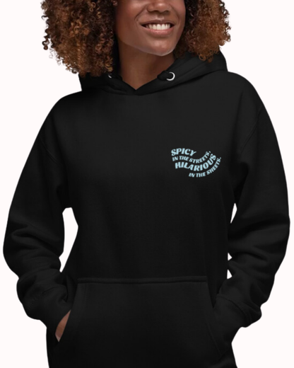 Front view of a black hoodie worn by a smiling woman, featuring the phrase 'Spicy in the streets, Hilarious in the sheets' on the chest and back. Perfect for fans of funny merchandise, bold humor, and witty sarcasm.