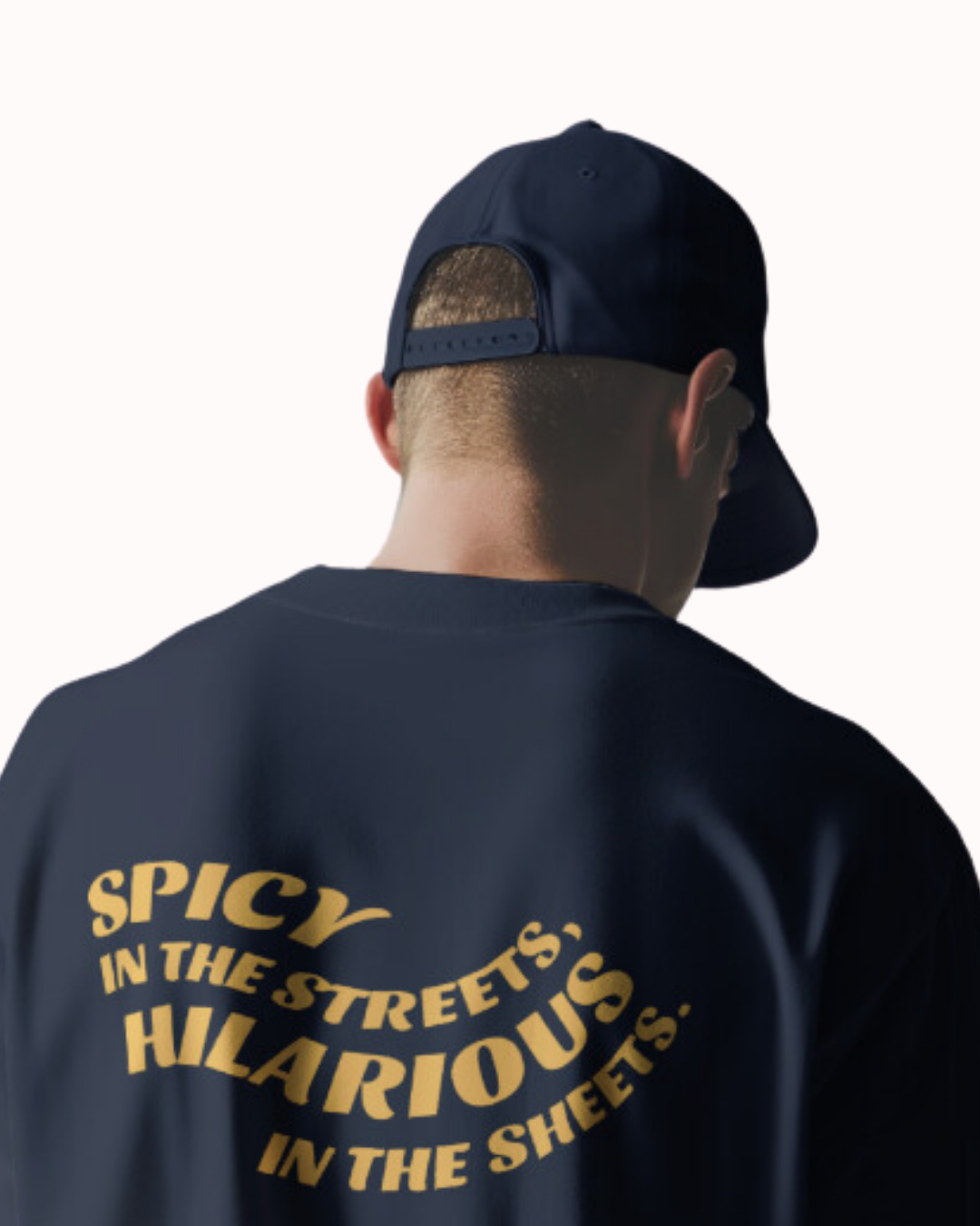 Back view of a navy T-Shirt featuring the phrase 'Spicy in the streets, Hilarious in the sheets' on the back. Perfect for fans of funny merchandise, bold humor, and witty sarcasm.