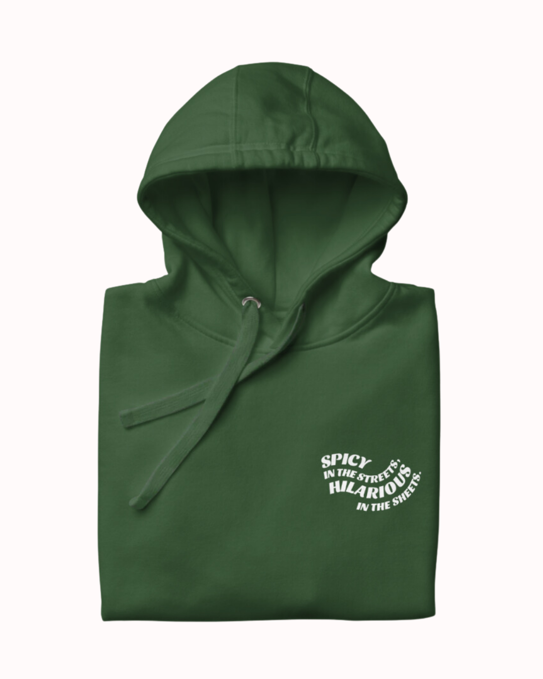 Folded forest green hoodie featuring the ironic phrase 'Spicy in the streets, Hilarious in the sheets'. Perfect for fans of funny merchandise, bold humor, and witty sarcasm.