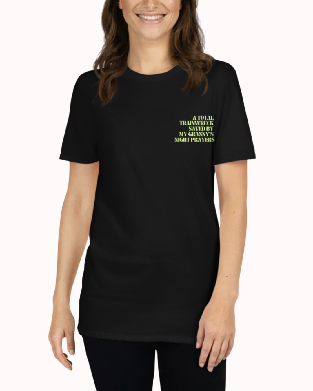 Front view of a Black t-shirt worn by a smiling woman, featuring the phrase "A total trainwreck saved my granny's night prayers" on the chest and back. Perfect for fans of funny merchandise, bold humor, and witty sarcasm.
