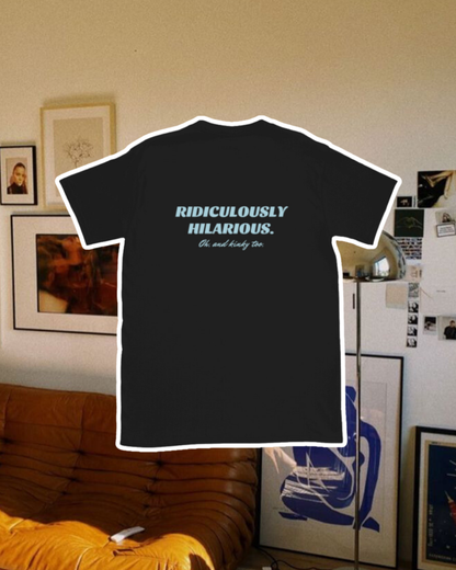 Black T-Shirt with the phrase 'Ridiculously hilarious. Oh, and kinky too' on the back, displayed against a vibrant living room with cozy elements and colorful frames. A playful and bold design for fans of funny merchandise and sarcasm.