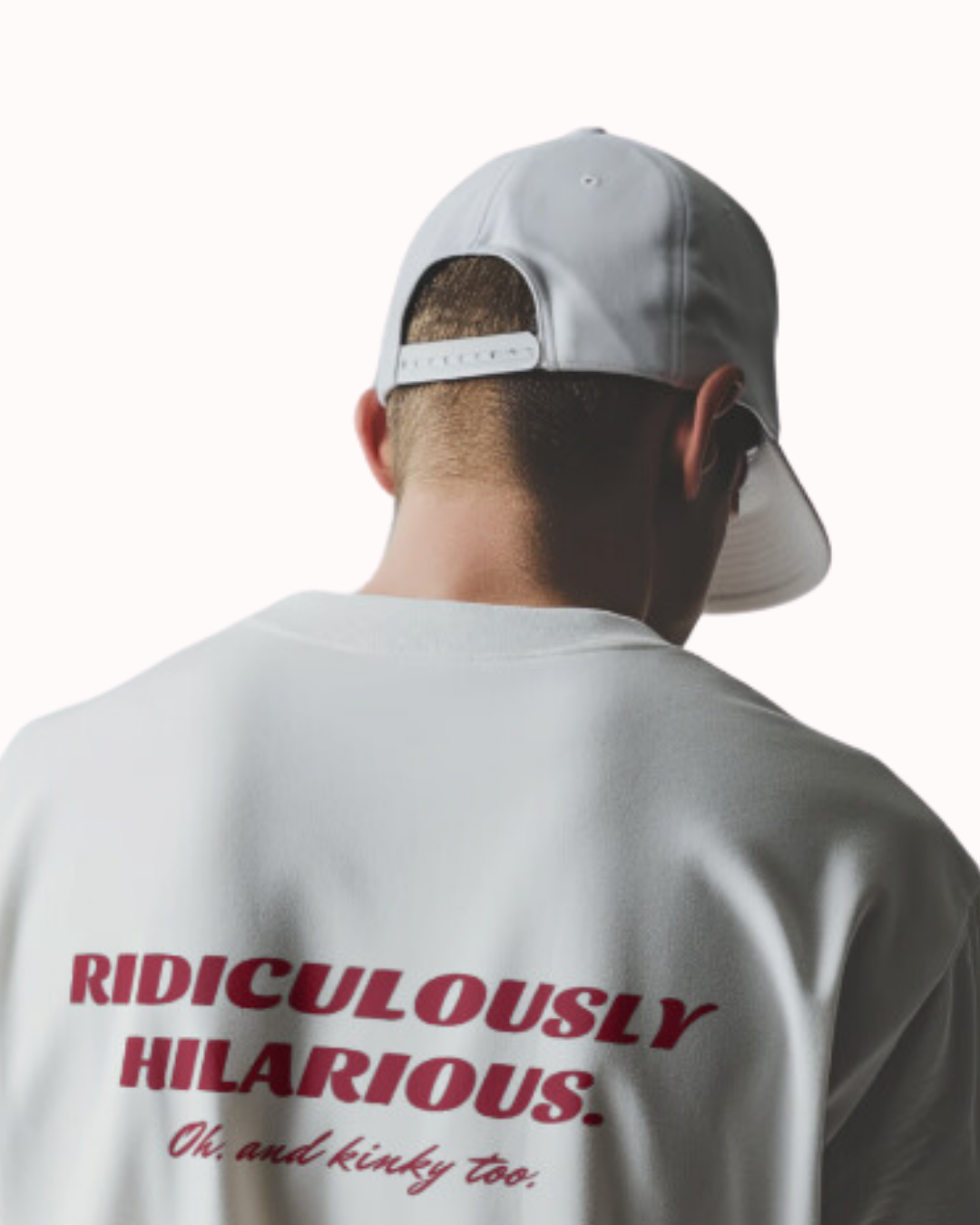 Back view of a white T-Shirt featuring the phrase 'Ridiculously hilarious. Oh, and kinky too' on the back. Perfect for fans of funny merchandise, bold humor, and witty sarcasm.