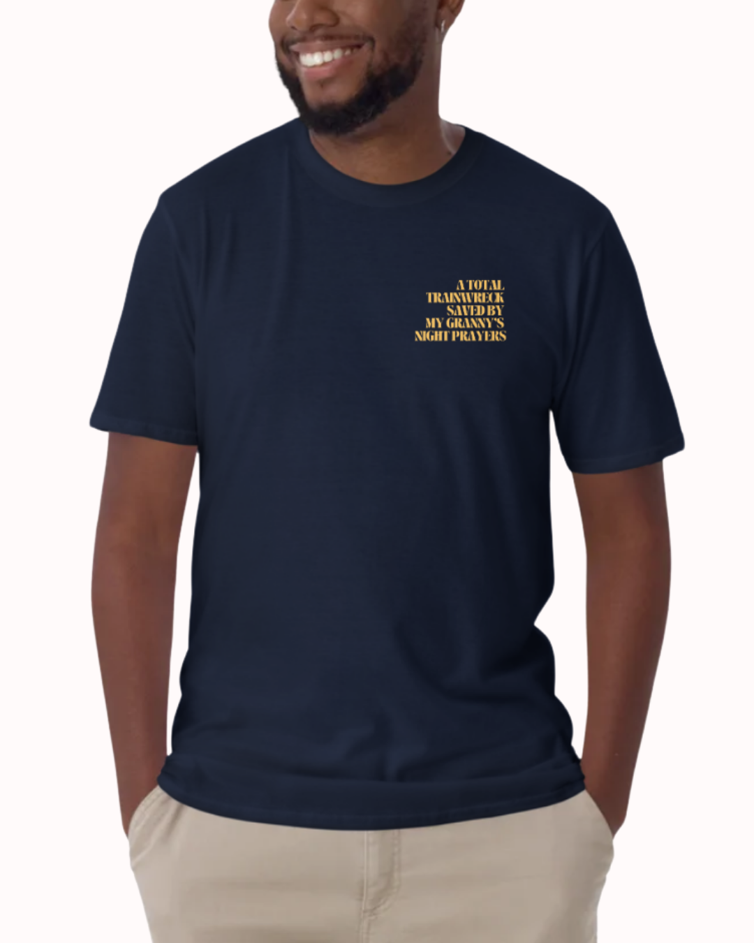 Front view of a Navy t-shirt worn by a smiling man, featuring the phrase "A total trainwreck saved my granny's night prayers" on the chest and back. Perfect for fans of funny merchandise, bold humor, and witty sarcasm.