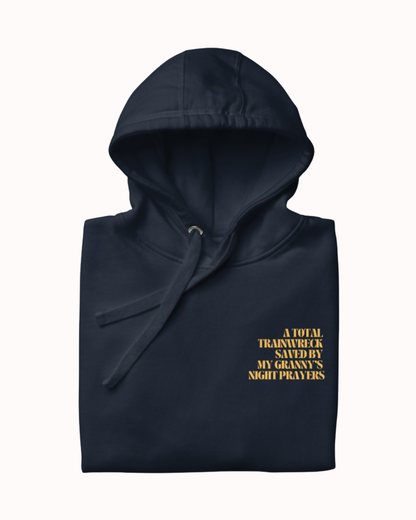 Folded Navy Blazer hoodie featuring the ironic phrase "A total trainwreck saved my granny's night prayers". Perfect for fans of funny merchandise, bold humor, and witty sarcasm.
