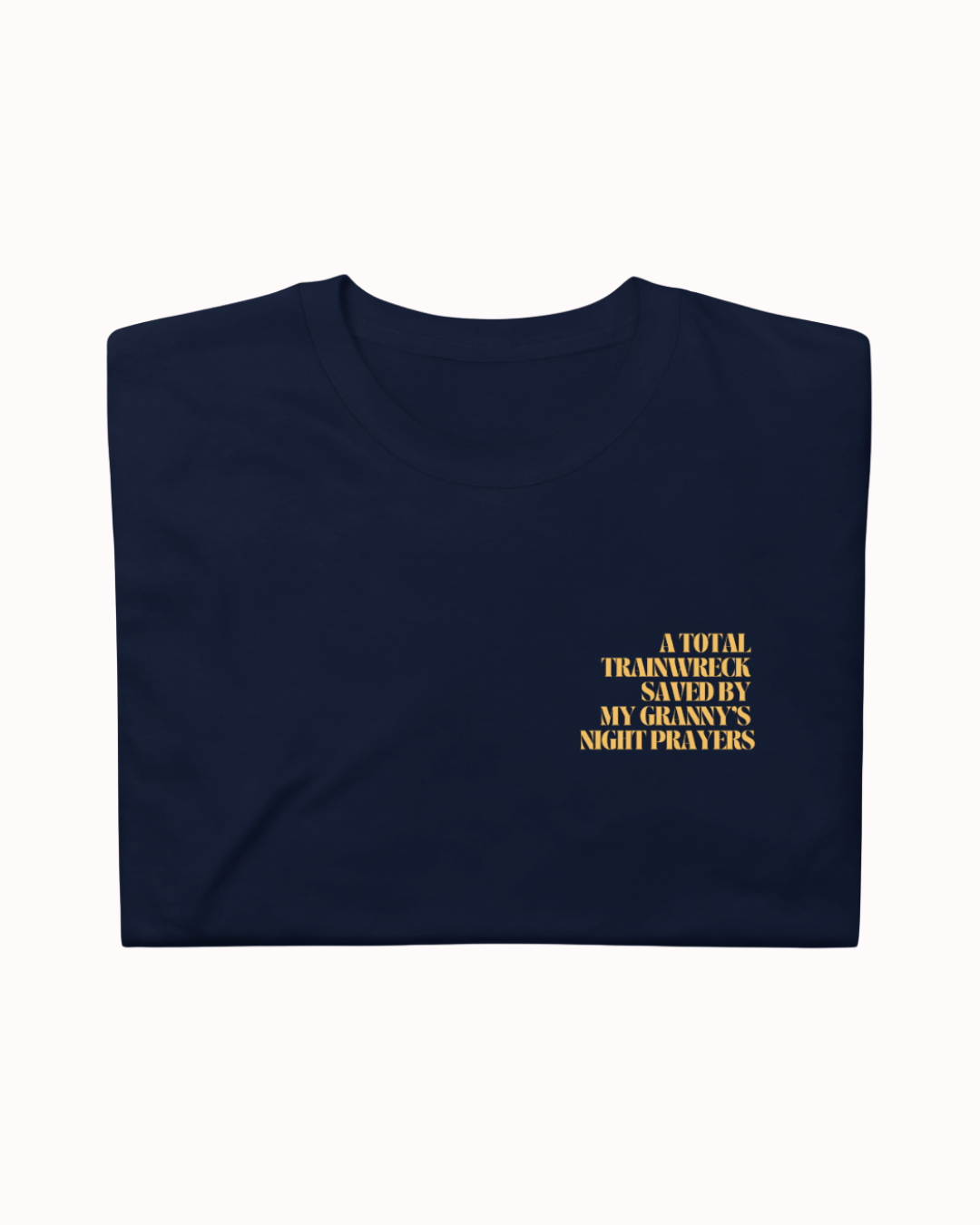Folded Navy t-shirt featuring the ironic phrase "A total trainwreck saved my granny's night prayers". Perfect for fans of funny merchandise, bold humor, and witty sarcasm.