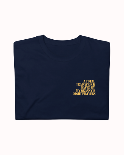 Folded Navy t-shirt featuring the ironic phrase "A total trainwreck saved my granny's night prayers". Perfect for fans of funny merchandise, bold humor, and witty sarcasm.