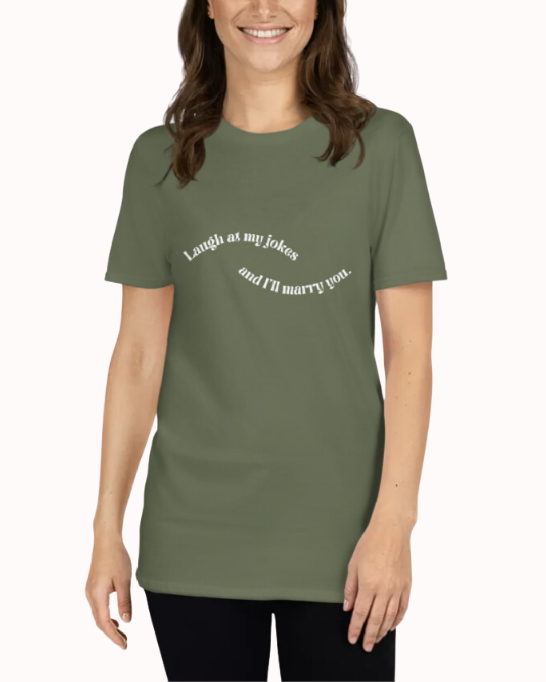 Front view of a military green T-Shirt worn by a smiling woman, featuring the phrase 'Laugh at my jokes and I will marry you' on the chest. Perfect for fans of funny merchandise, bold humor, and witty sarcasm.