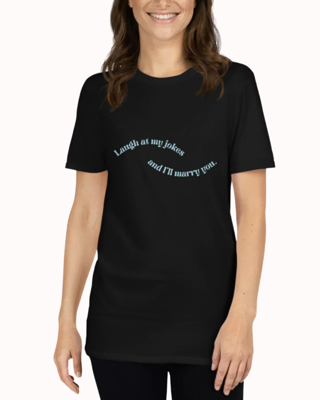 Front view of a black T-Shirt worn by a smiling woman, featuring the phrase 'Laugh at my jokes and I will marry you' on the chest. Perfect for fans of funny merchandise, bold humor, and witty sarcasm.