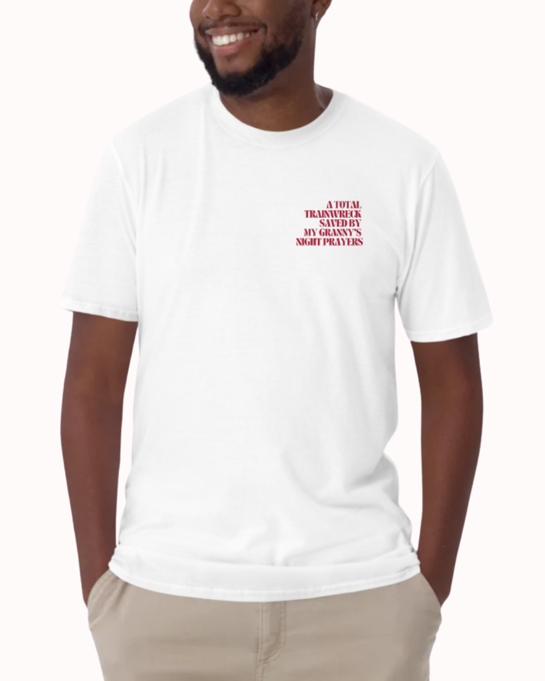 Front view of a White t-shirt worn by a smiling man, featuring the phrase "A total trainwreck saved my granny's night prayers" on the chest and back. Perfect for fans of funny merchandise, bold humor, and witty sarcasm.