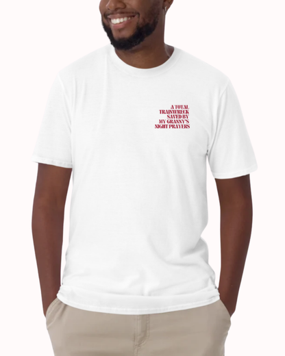Front view of a White t-shirt worn by a smiling man, featuring the phrase "A total trainwreck saved my granny's night prayers" on the chest and back. Perfect for fans of funny merchandise, bold humor, and witty sarcasm.