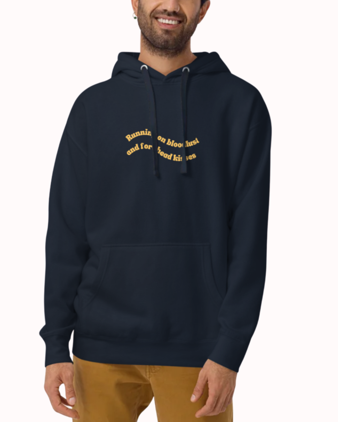Front view of a Navy Blazer hoodie worn by a smiling man, featuring the phrase "Running on bloodlust and forehead kisses" on the chest and back. Perfect for fans of funny merchandise, bold humor, and witty sarcasm.