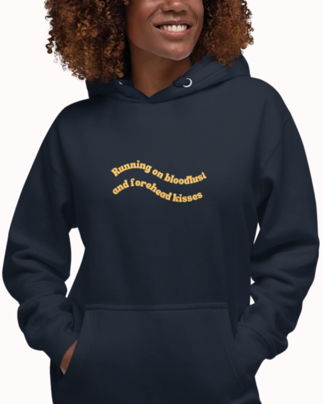 Front view of a Navy Blazer hoodie worn by a smiling woman, featuring the phrase "Running on bloodlust and forehead kisses" on the chest and back. Perfect for fans of funny merchandise, bold humor, and witty sarcasm.