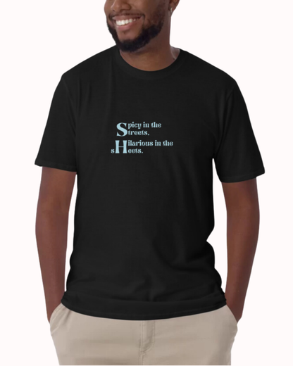 Front view of a black T-Shirt worn by a smiling man, featuring the phrase 'Spicy in the streets, Hilarious in the sheets' on the chest. Perfect for fans of funny merchandise, bold humor, and witty sarcasm. 