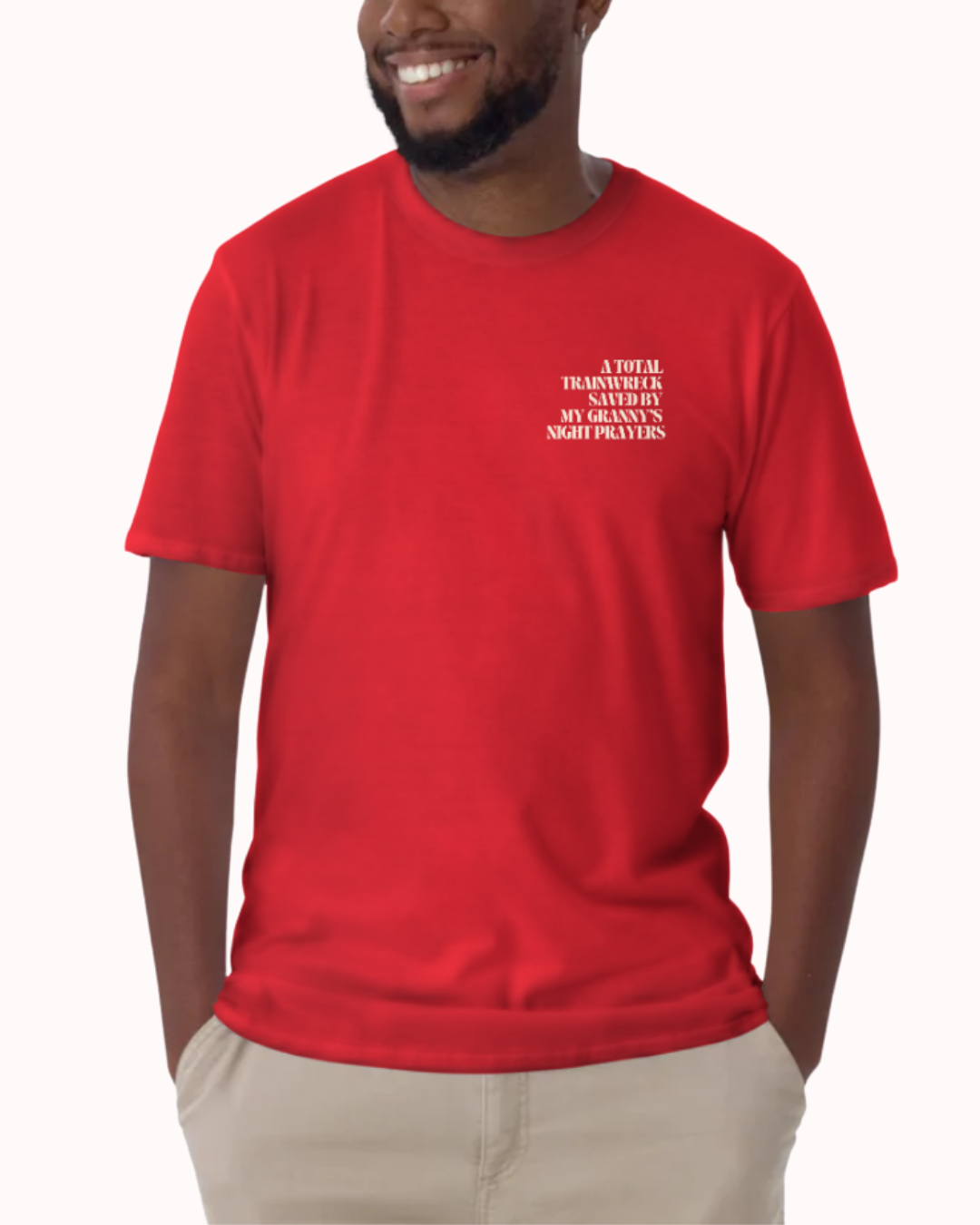Front view of a Red t-shirt worn by a smiling man, featuring the phrase "A total trainwreck saved my granny's night prayers" on the chest and back. Perfect for fans of funny merchandise, bold humor, and witty sarcasm.
