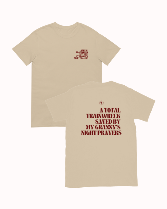 Front and back view of a Sand t-shirt featuring the phrase "A total trainwreck saved my granny's night prayers" on the back. Perfect for fans of funny merchandise, bold humor, and witty sarcasm.