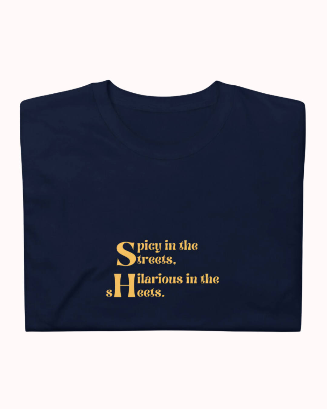 Folded navy T-Shirt featuring the ironic phrase 'Spicy in the streets, Hilarious in the sheets'. Perfect for fans of funny merchandise, bold humor, and witty sarcasm. 