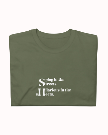 Folded military green T-Shirt featuring the ironic phrase 'Spicy in the streets, Hilarious in the sheets'. Perfect for fans of funny merchandise, bold humor, and witty sarcasm. 