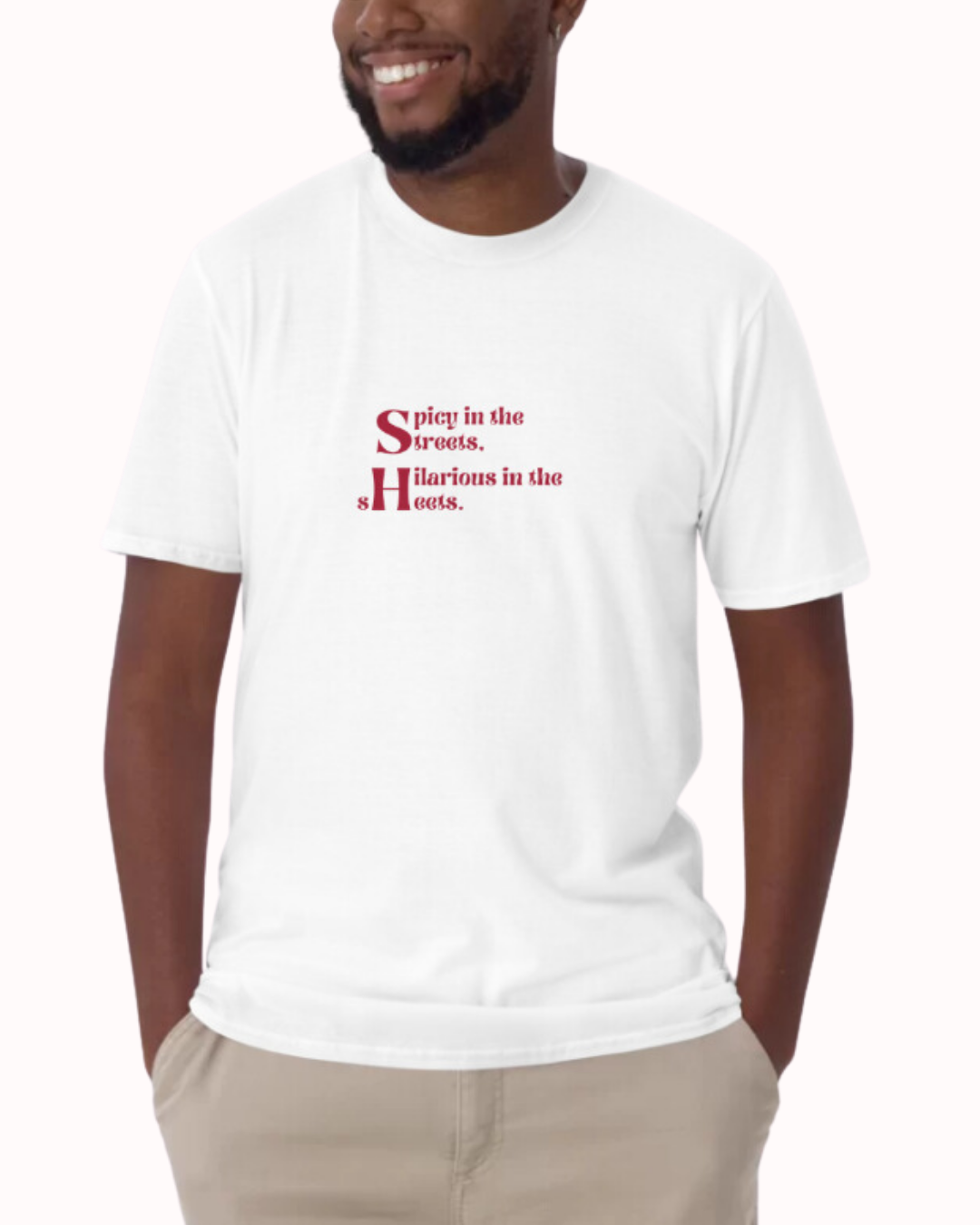 Front view of a white T-Shirt worn by a smiling man, featuring the phrase 'Spicy in the streets, Hilarious in the sheets' on the chest. Perfect for fans of funny merchandise, bold humor, and witty sarcasm. 