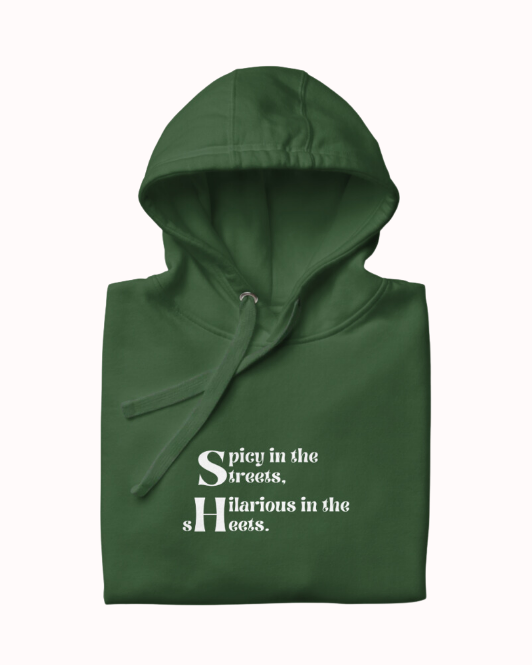 Folded forest green hoodie featuring the ironic phrase 'Spicy in the streets, Hilarious in the sheets'. Perfect for fans of funny merchandise, bold humor, and witty sarcasm.